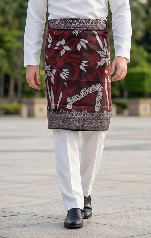 Person wearing a traditional Sampin Instant Tanjung Burgundy traditional tenun pattern instant and black shoes on a blurred outdoor background.