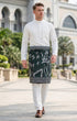 Man wearing a traditional outfit Sampin Instant Tanjung Emerald Silver in an outdoor setting.
