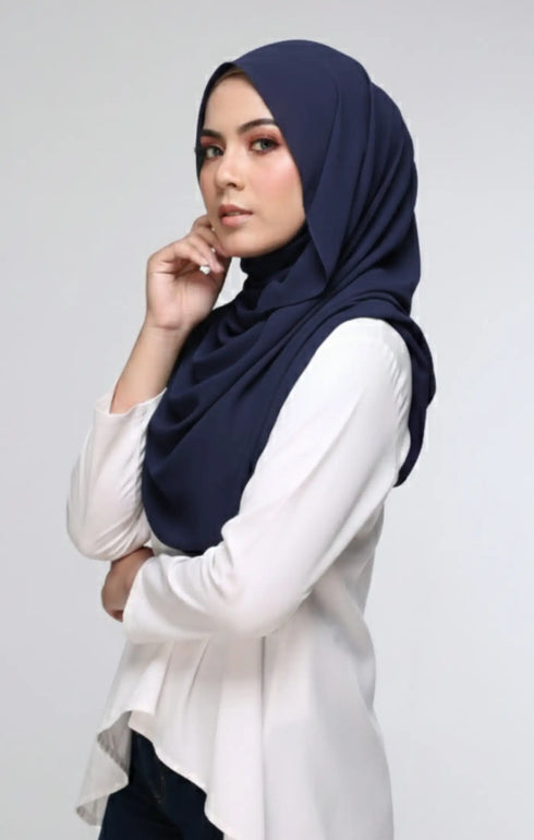 Woman wearing a Semi Instant Shawl HIjab Blue Black side view highlighting flowy edge and generous width and white blouse against a light gray background