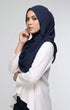 Woman wearing a Semi Instant Shawl HIjab Blue Black side view highlighting flowy edge and generous width and white blouse against a light gray background