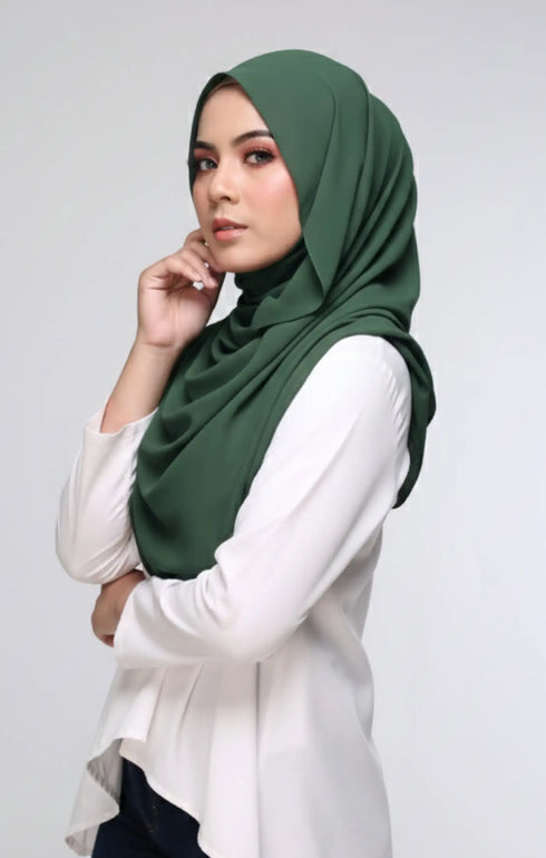 Woman wearing a Semi Instant Shawl Plain Hijan Emerald Green side drape view highlighting flowing edge and generous width with Pearl White blouse against a plain background