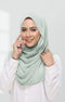 Woman wearing a Semi Instant Shawl Plain Hijab Dusty Green front drape view showing full length and premium Korean chiffon and white shirt against a plain background
