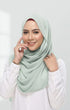 Woman wearing a Semi Instant Shawl Plain Hijab Dusty Green front drape view showing full length and premium Korean chiffon and white shirt against a plain background