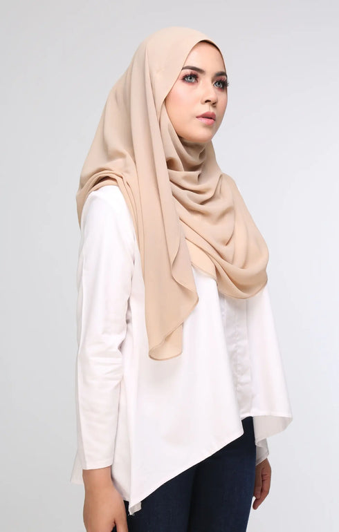 Woman wearing a Nude Semi instant shawl plain front drape view showing full length and soft chiffon texture on a gray background