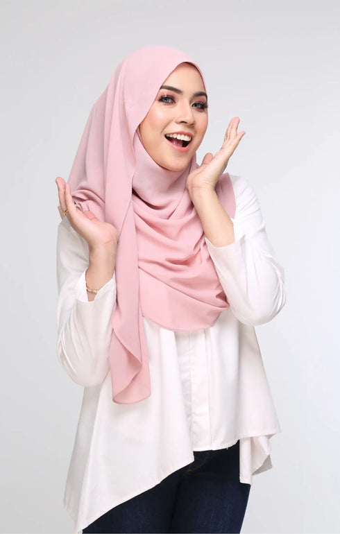 Woman wearing a Semi Instant Shawl Plain hijab Rose Gold and white shirt top on a plain background