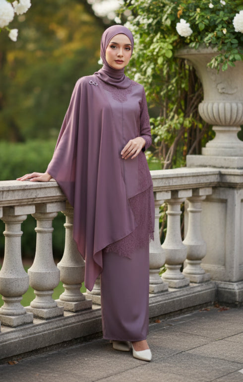 Woman in a Kebaya Moden Dusty Magenta outfit standing on a stone balcony with greenery in the background