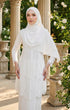 Woman in a Pearl white dress Kebaya Moden and pearl white instant shawl hijab standing outdoors with classical architecture and flowers in the background