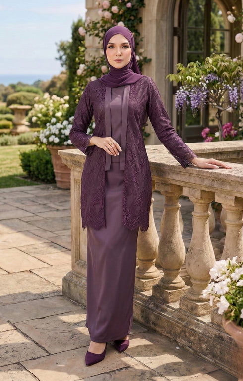 Woman wearing kebaya Kutu Baru Dusty Magenta front view showing V‑neck collar and French lace detailing standing outdoors with floral decorations.