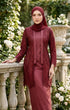 Woman in a Close-up of kebaya Kutu Baru Maroon showing delicate French lace pattern and smooth cotton texture standing outdoors near flowers and stone balustrade.