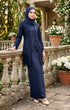 Woman in a baju kebaya Kutu Baru Navy Blue outfit standing outdoors with floral arrangements in the background