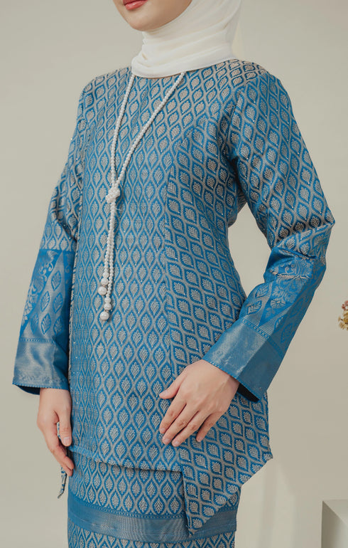 Fabric close up C Luxe Kurung Kedah Teal Blue showing dyed brocade texture and pattern