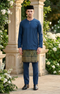 Man wearing a Baju Melayu Teluk Belanga Dark Teal Blue traditional outfit with a sampin Exclusive 3d skirt, standing in a decorative garden.