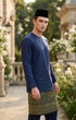 Man wearing a traditional outfit Baju Melayu Teluk Belanga Navy Blue an outdoor setting.