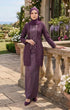 Woman in a kebaya Kutu Baru Dusty Magenta outfit standing outdoors with floral decorations.