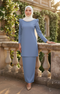 Woman in a Kurung Moden Plain Dusty Blue front view slim fit round neck with puff shoulder with greenery in the background