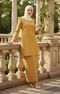 Woman in a Kurung moden plain mustard full outfit view with greenery in the background