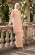 Woman in a Kurung moden plain Peach full side view outfit standing on a stone balcony with floral decorations.