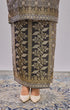 Fabric close up Kurung Moden Black Gold showing dyed brocade texture and gold accents on decorative floor