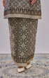 Traditional Kurung Moden Black Gold Orchid displaying outfit on a patterned floor