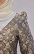 Kurung Moden Black Gold Orchid showing dyed brocade texture with a instant shawl white hijab on a gray background