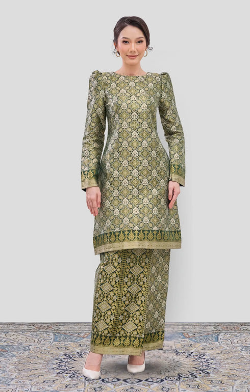 Woman wearing a Emerald Green Gold Traditional Kurung Moden showing brocade woven design on a white background