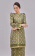 Woman wearing Kurung Moden Emerald Green Gold showing brocade woven design traditional outfit on a gray background