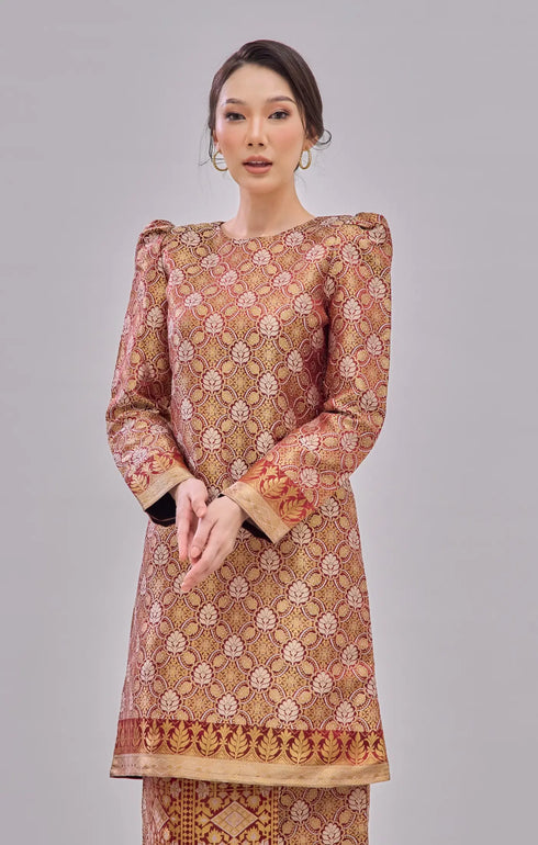 Woman wearing a Kurung Moden Maroon Gold Orchid highlighting long straight sleeve outfit on a gray background