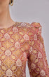 Close-up of a Kurung Moden Maroon Gold Orchid brocade woven design on a plain background
