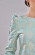 Kurung Moden Mint Green Gold highlighting fabric with a gray background