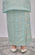 Kurung Moden Mint Green Gold showing dyed brocade texture skirt with white shoes on a patterned floor