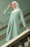 Woman wearing Kebarung Klasik Dusty Green front view highlighting long sleeves and breathable plain cotton fabric