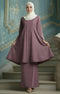 Kebarung Dusty Magenta traditional outfit standing on a staircase with a decorative blue wall in the background.