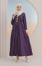 A model wearing a Jubah Kebarung Klasik Dark Purple, V-neck, long-sleeved, cotton plain traditional dress with a side pocket, standing in a circular mirrored background.