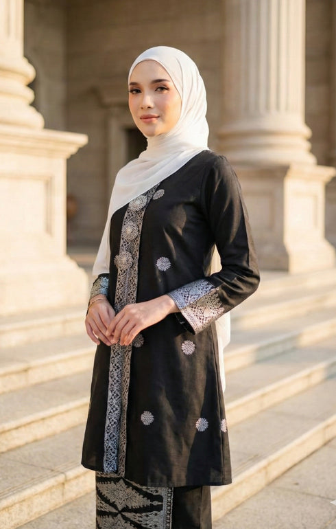 Woman wearing a Kebaya Black Silver showing songket floral pattern outfit with pearl white shawl in an outdoor setting