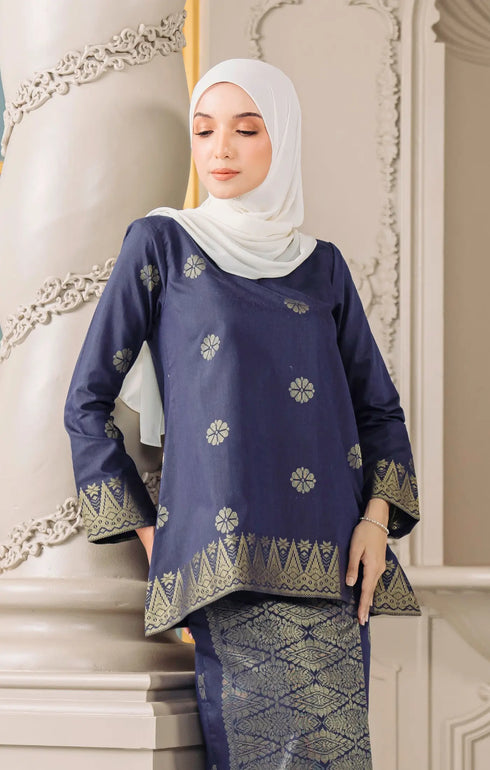 Fabric close up woman wearing a Kurung Kedah Blue Black Gold showing woven songket texture and gold pattern