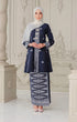 Model wearing Kebaya Blue Black Silver traditional outfit displaying overall styling and drape with shawl white hijab in an elegant interior setting