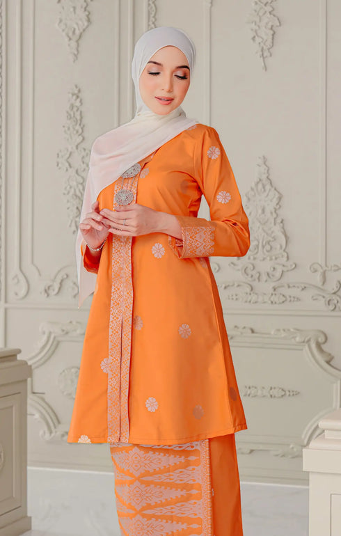 Model wearing Kebaya Orange Silver displaying traditional styling and drape