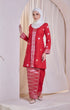 Woman wearing a Kebaya Red Chilli Silver showing songket floral pattern traditional outfit with white patterns against a white curtain background
