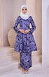 Woman wearing a Kebarung Pasley Dusty Blue showing pasley cotton print and fit with a instant shawl peral white hijab in a minimalistic setting.