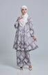 Woman wearing a Kebarung Black White highlighting long straight sleeve and silhouette with a instant shawl hijab on a gray background