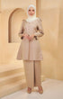 A woman wearing a Kurung Riau Plain Light Coffee, slim-fit traditional with long straight sleeves and a round V-neck cut, paired with matching trousers.