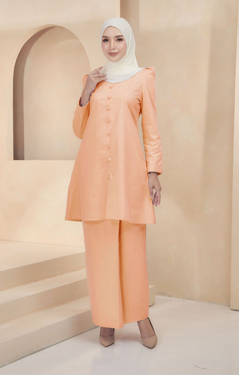 Kurung Riau Plain Peach styling shot showing shoulder puff and long straight sleeves