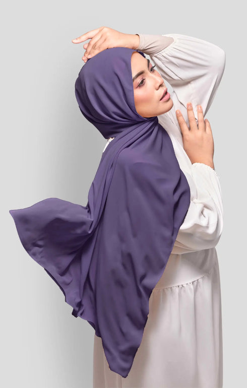 Woman wearing a Purple Royal Satin Shawl Plain Hijab side view highlighting flowy edge and generous width white outfit against a Plain background