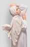 Woman wearing a Royal Satin Shawl Plain Hijab Sand front drape view showing full length and smooth satin fabric with White outfit against a light gray background