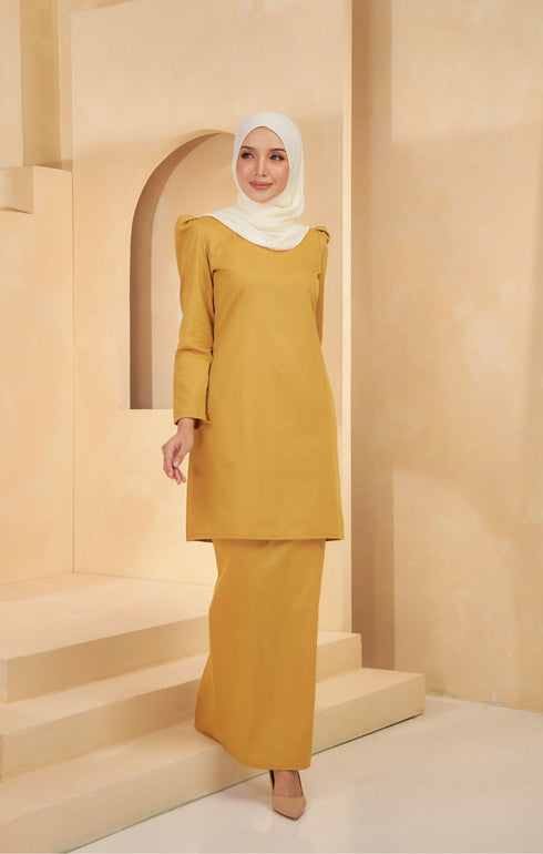 Model walking in Kurung Moden Plain Mustard, showing full kurung shape and plain design