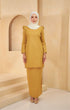 A woman wearing a Kurung Moden Plain Mustard front view traditional kurung set with a round neck and long sleeves, paired with matching trousers.