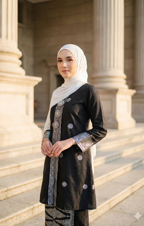 Woman wearing a Kebaya Black Silver showing songket floral pattern outfit with pearl white Hijab in an outdoor setting