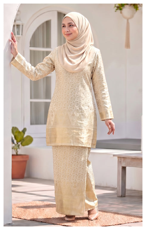 Model wearing Myra Kurung Moden Off White full outfit with lipat depan kain and lining in an outdoor setting.